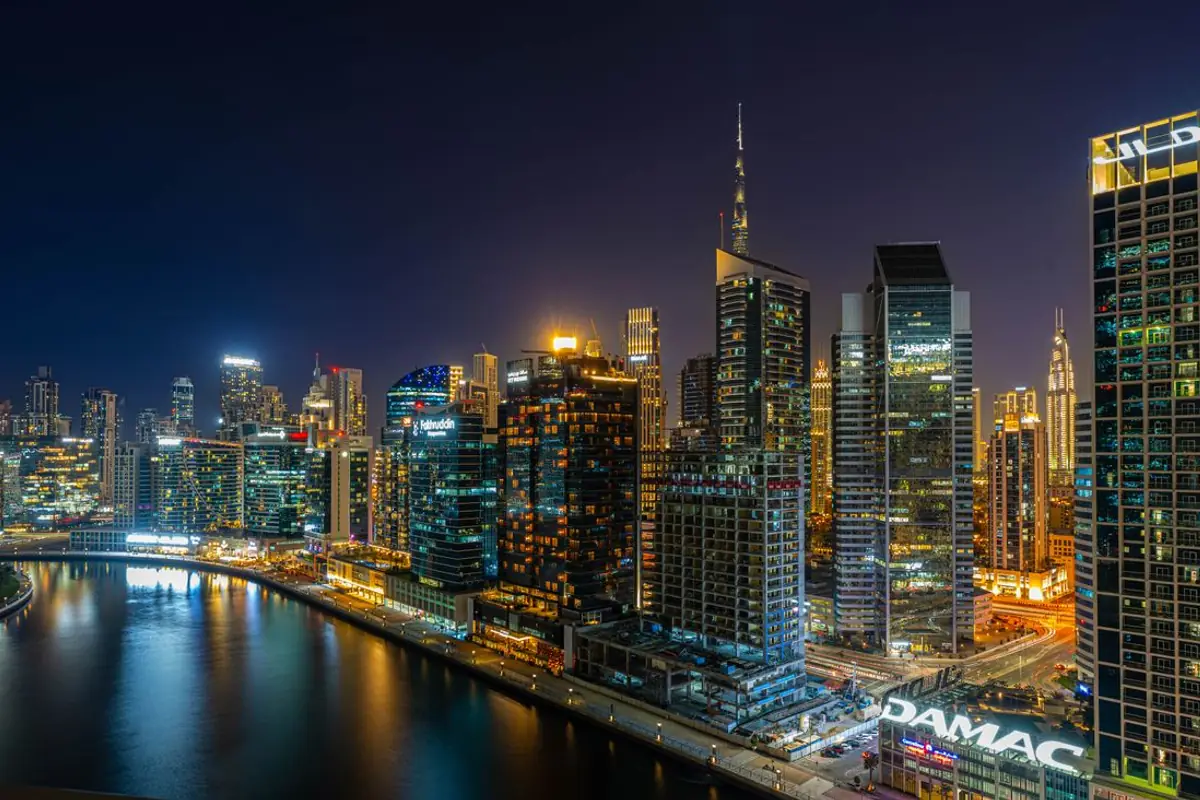 Business Bay's towers lit at night along Dubai Water Canal, where the Bestax office sits.