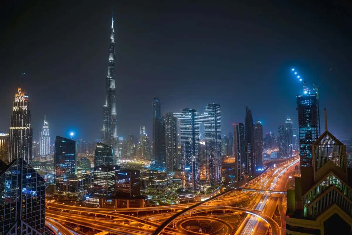 Downtown Dubai skyline at night behind the Bestax services list