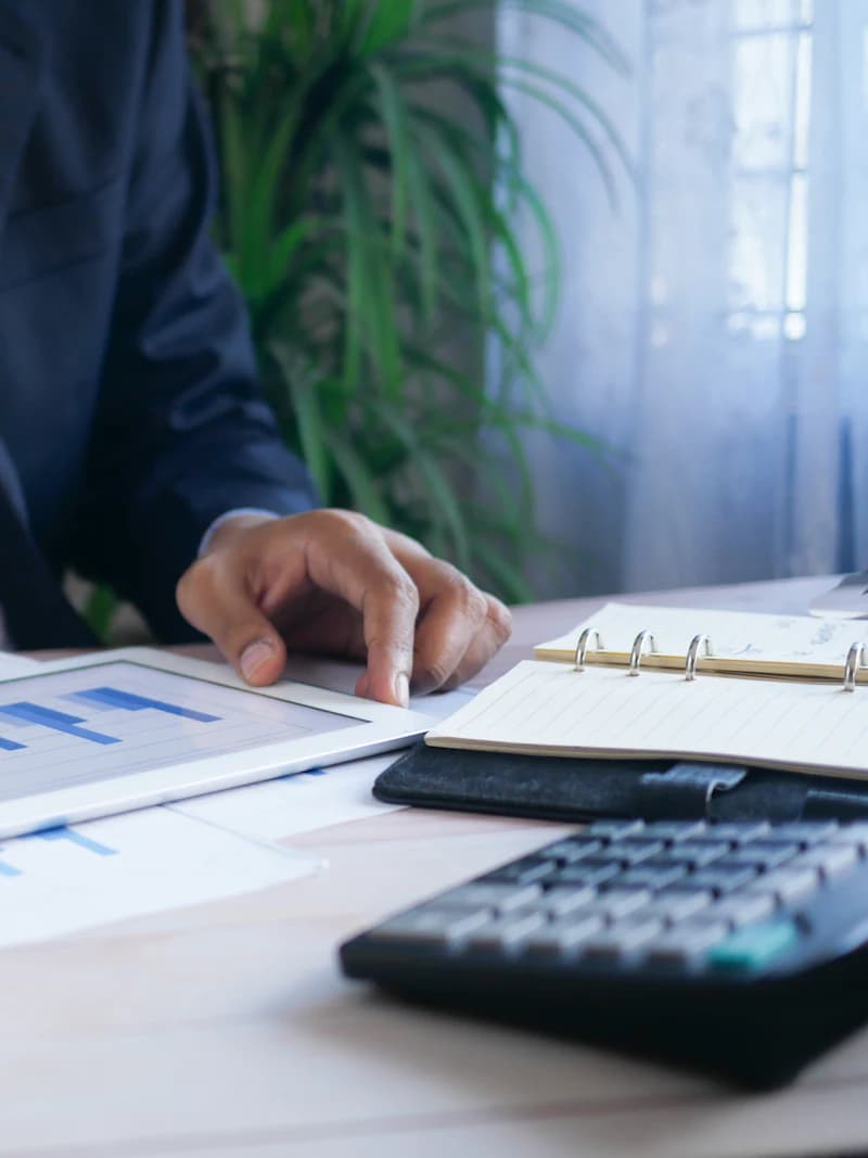 A Bestax accountant working through a set of accounts and supporting invoices at a desk.