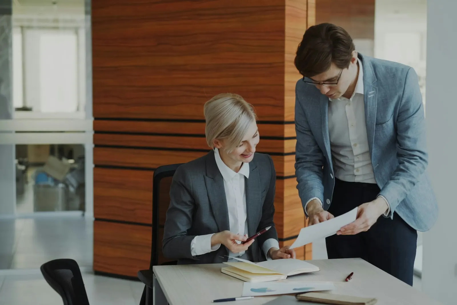 Two Bestax advisers checking a client's closure file together at an office desk.