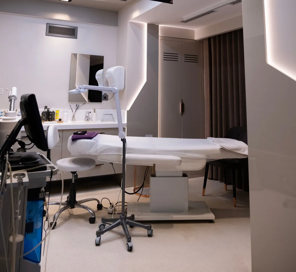 Modern treatment room in a clinic with a patient bed and strip lighting