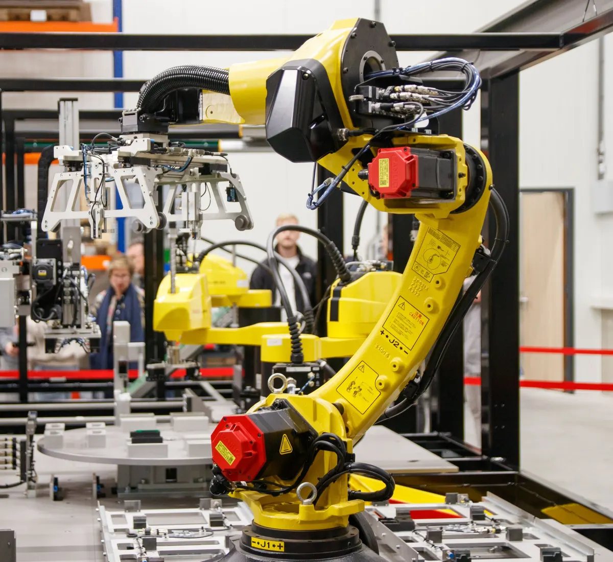 Yellow industrial robot arm working on an automated factory line