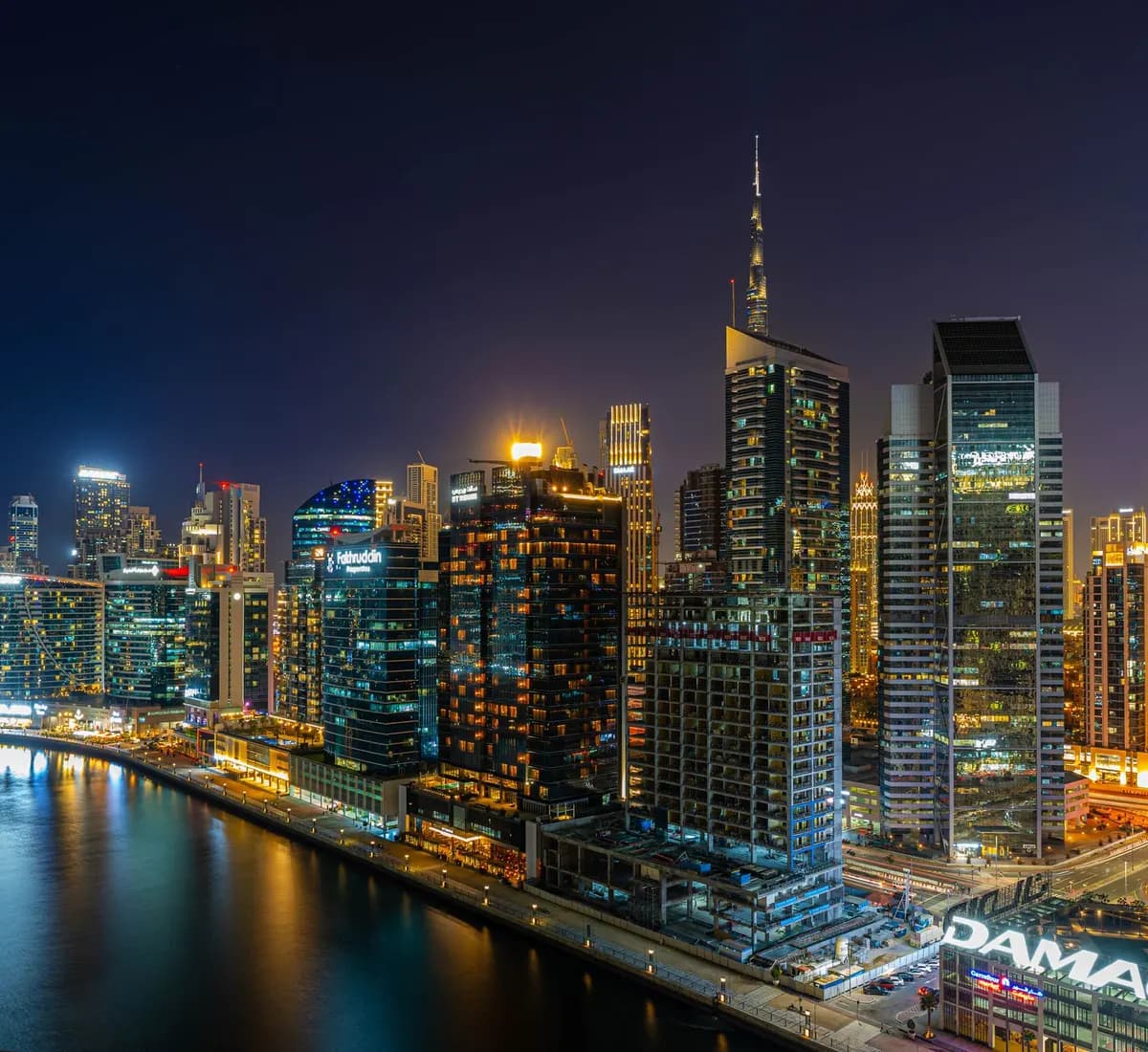 Dubai's Business Bay towers lit up at night along the canal