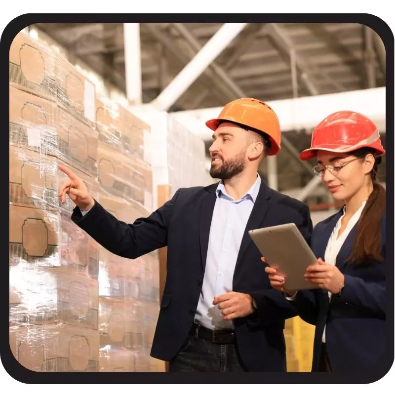 Two professionals inspecting inventory in a warehouse.